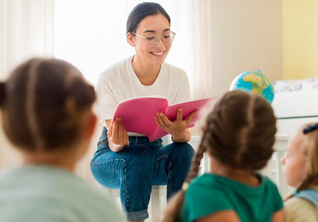front-view-woman-reading-something-her-students_23-2148633356 front-view-woman-reading-something-her-students_23-2148633356