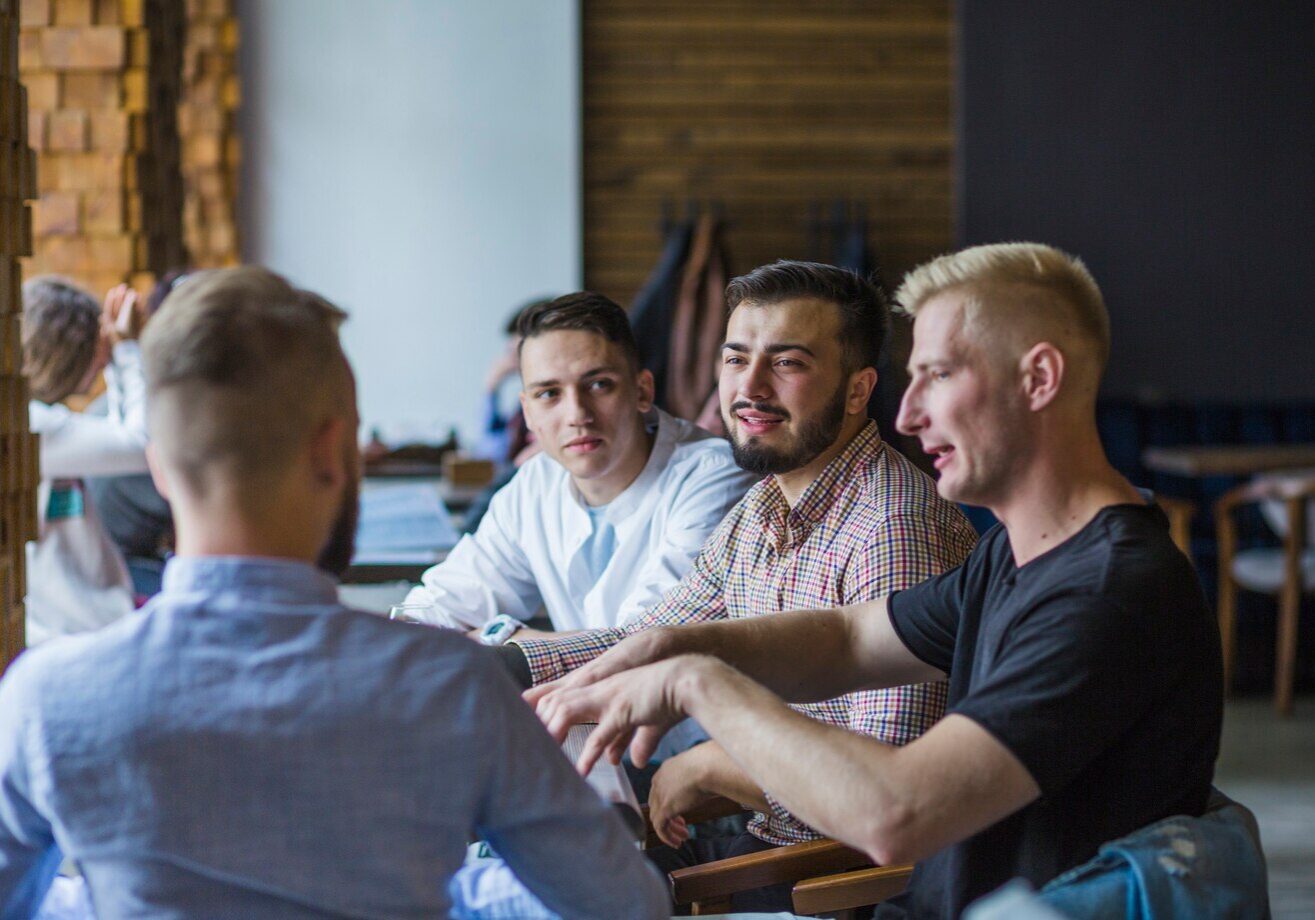 young-man-sitting-restaurant-explaining-strategy-his-friends_23-2147861884 young-man-sitting-restaurant-explaining-strategy-his-friends_23-2147861884